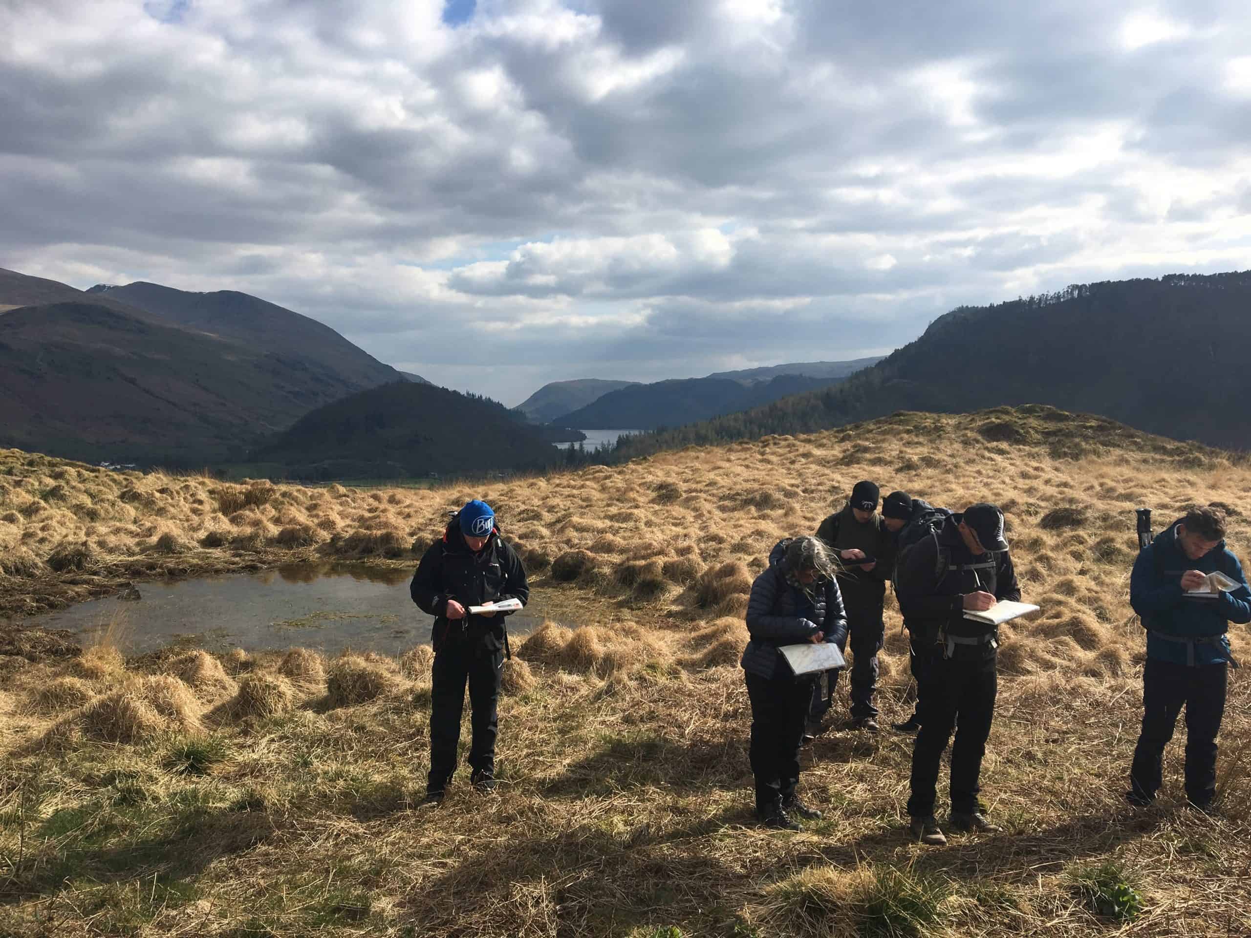 Studying map and compass during mountain skills course