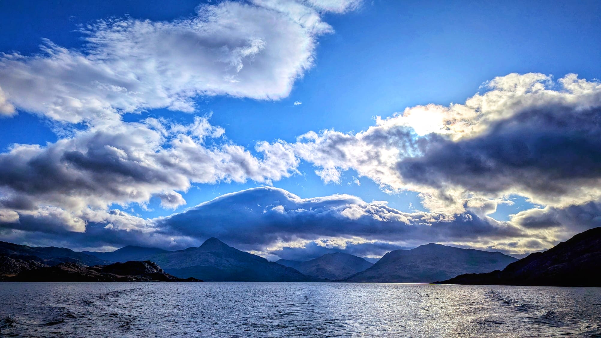 Snow-covered mountain peak above Knoydart under dramatic blue sky and cloud