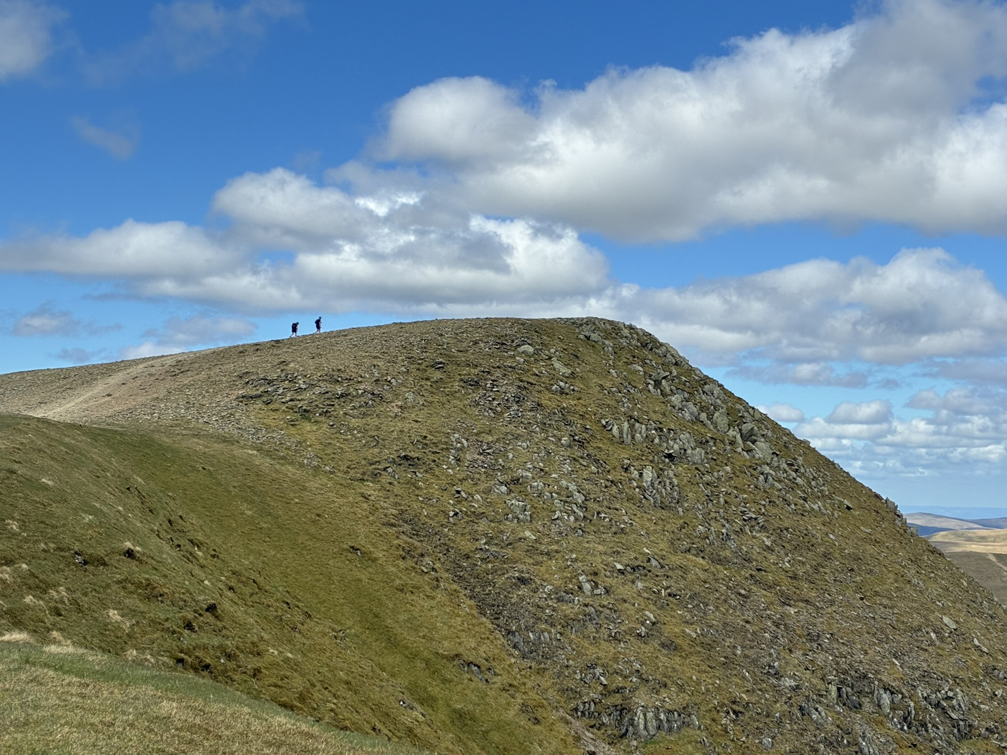 Ridgeline walking in the Northern Fells beneath blue skies during a Lake District wild camp