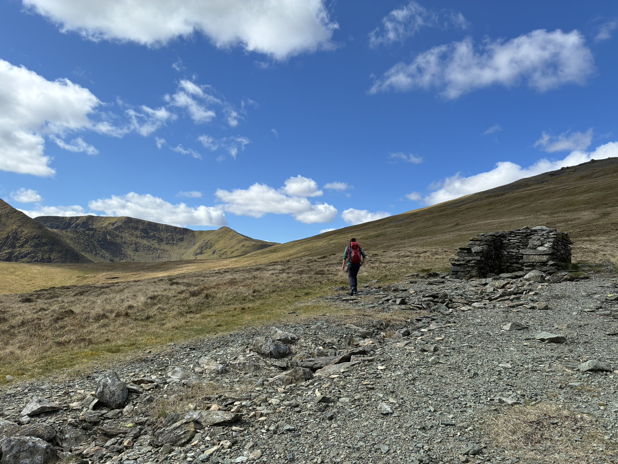Walker crossing open ridge terrain in the Northern Fells on a guided overnight wild camp