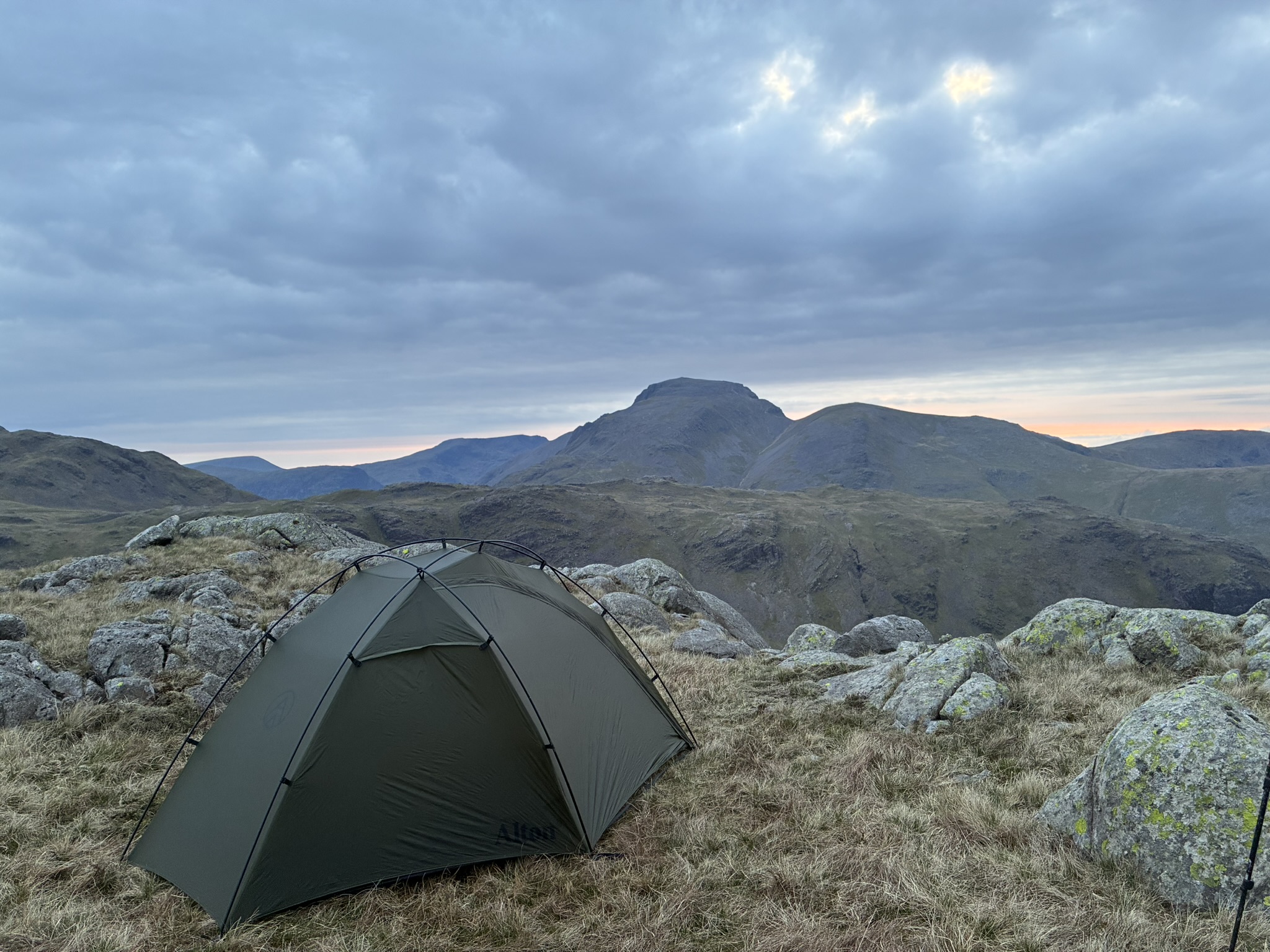 Wild camping tent pitched high in the Lake District during a calm mountain evening