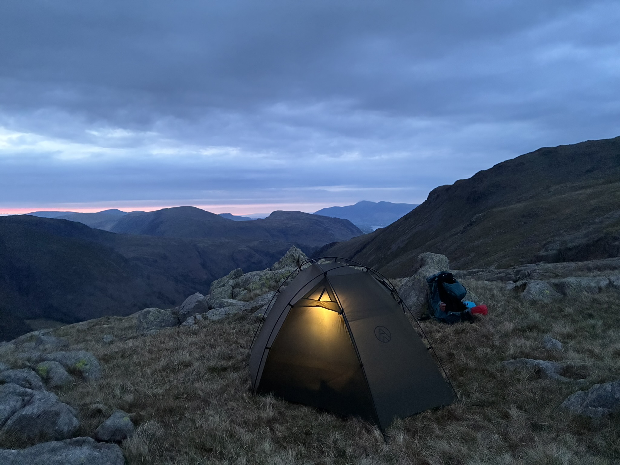 Tent glowing at dusk during a guided overnight wild camping experience in the Lake District
